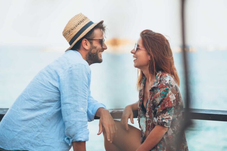a smiling man and woman look at each other