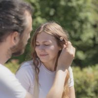 man putting a flower in his girlfriend's hair