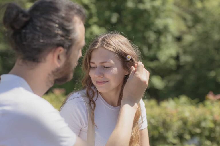 man putting a flower in his girlfriend's hair