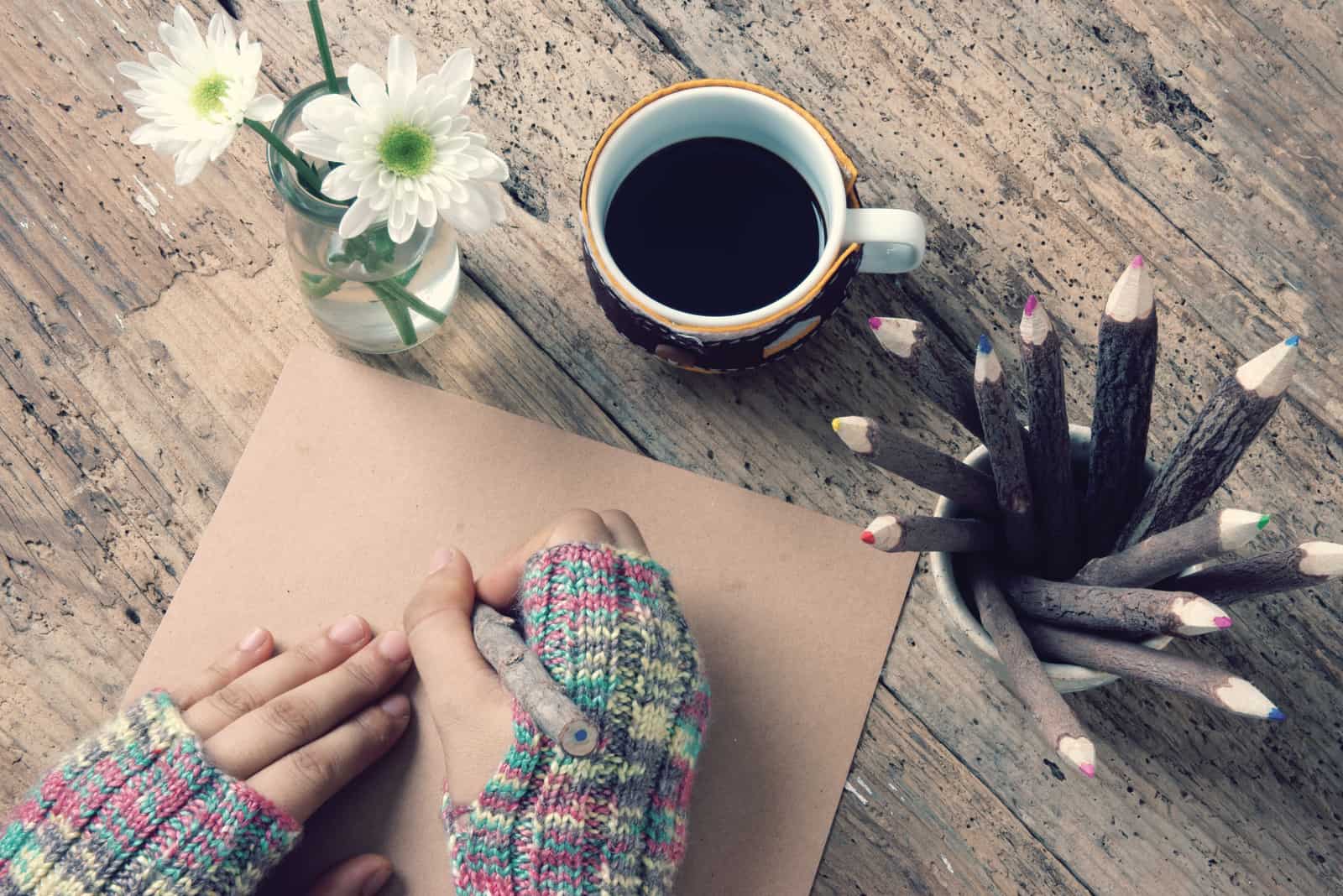 As mãos das mulheres usam luvas de lã no inverno, escrevendo cartas para ele