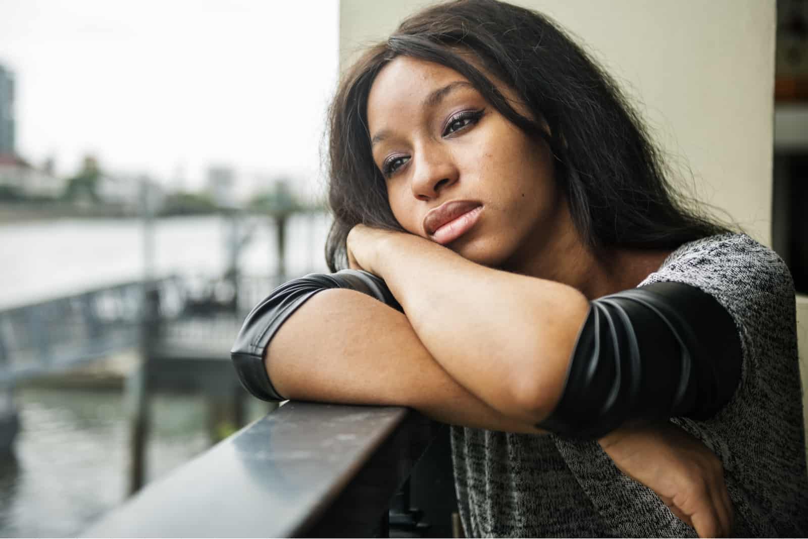 una donna afroamericana depressa è seduta sul balcone