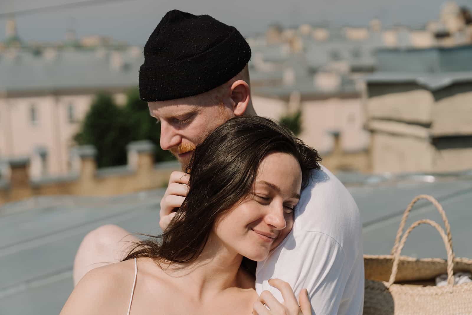 a loving couple hugging while sitting on the rooftop