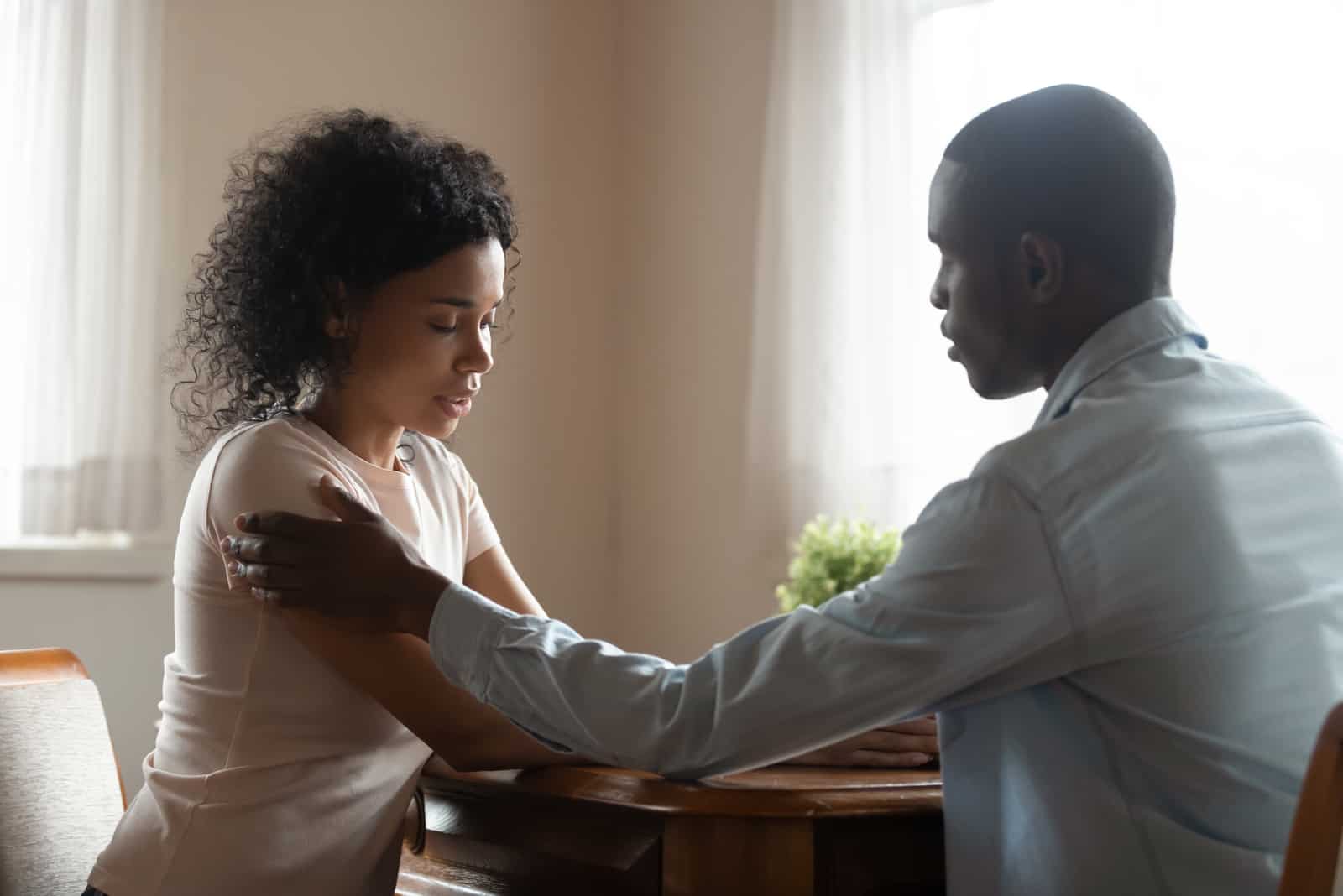 una pareja triste hablando en la cocina