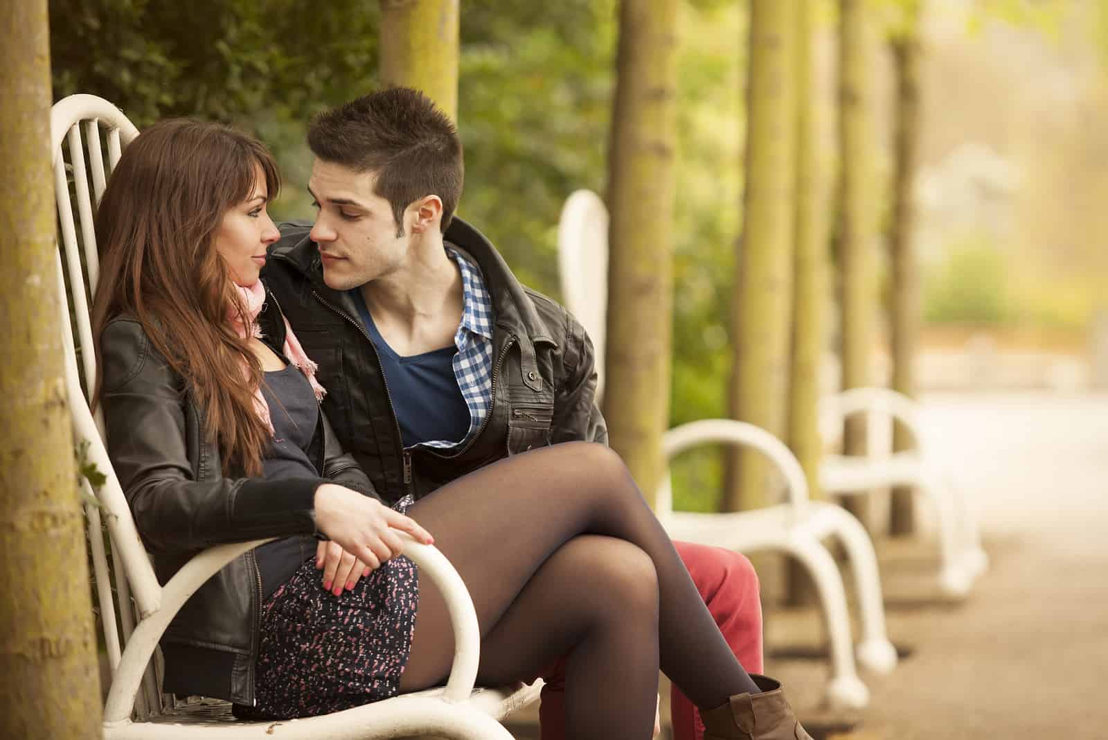 una giovane coppia seduta a flirtare nel parco