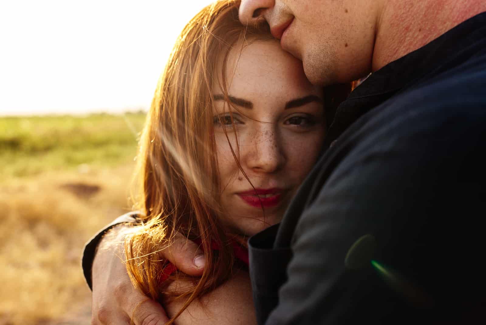 at sunset a man hugs a girl tightly