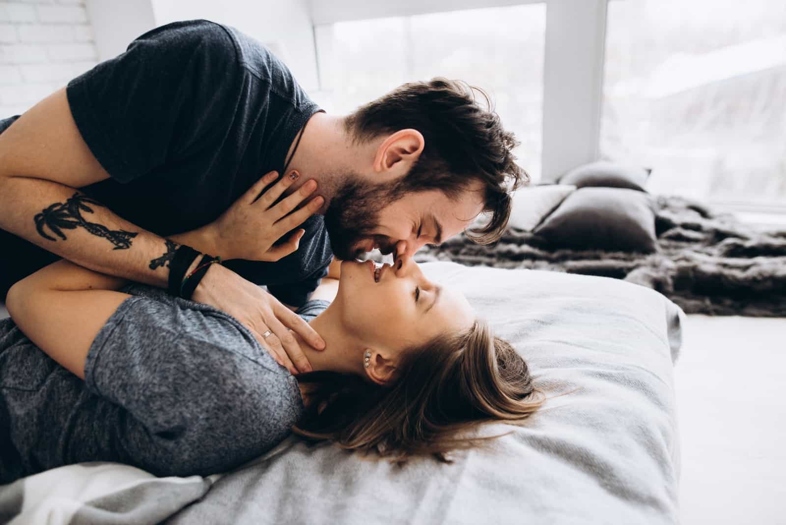 man and woman about to kiss while laying on bed