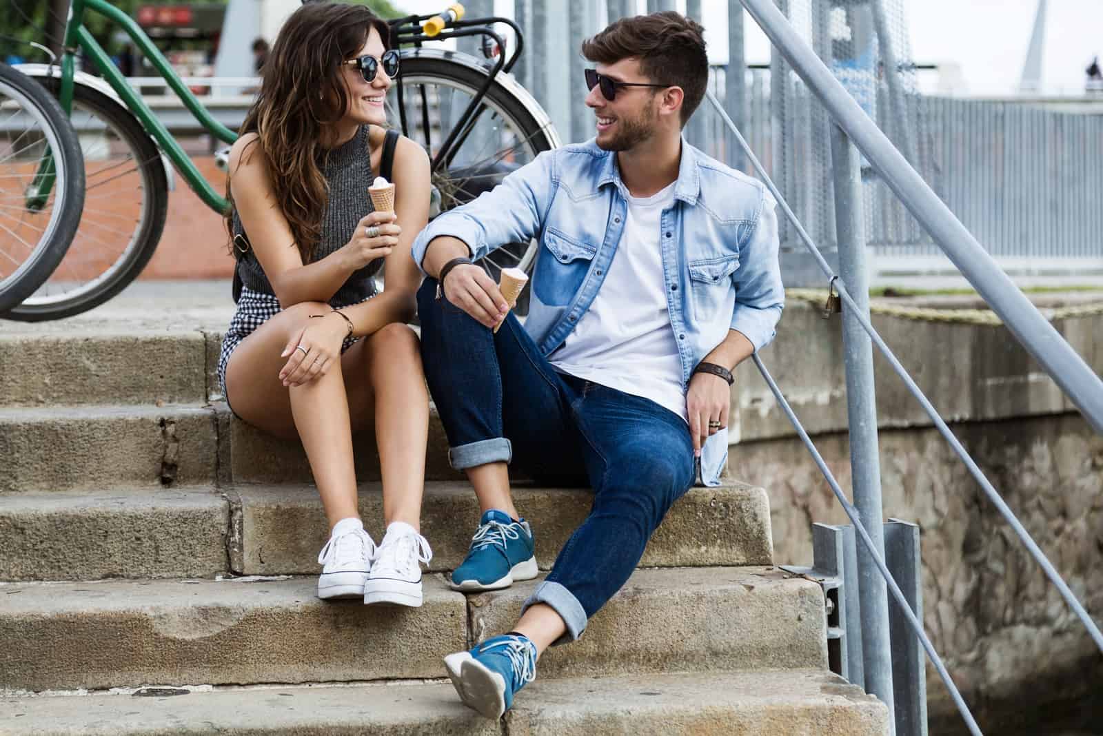 man and woman eating ice cream while sitting on stairs