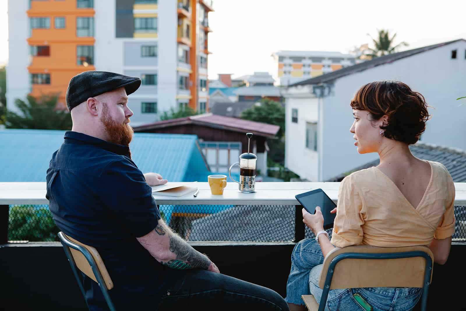 man and a woman cheating while drinking coffee on a terrace