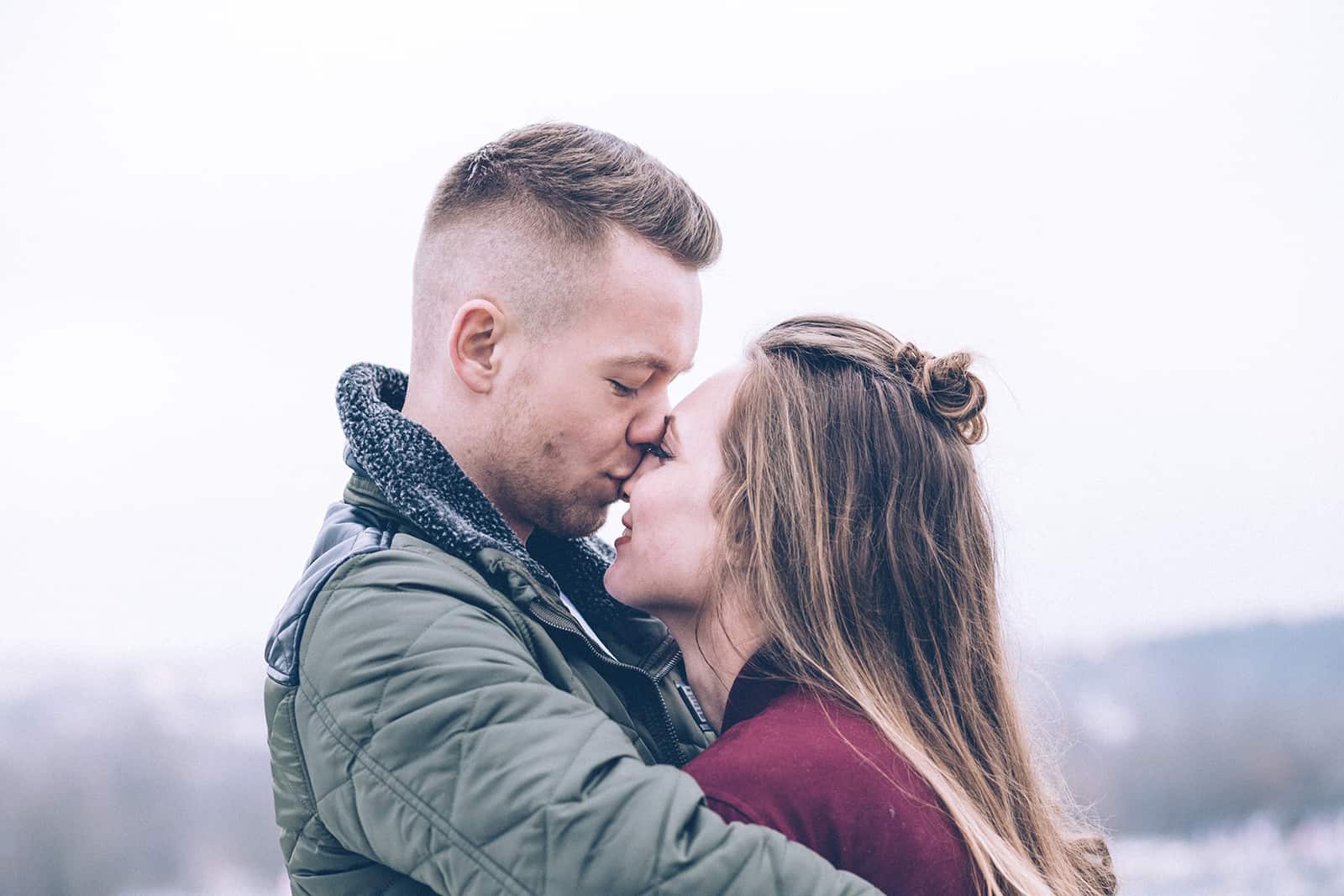 man embracing his girlfriend and kissing her in the nose