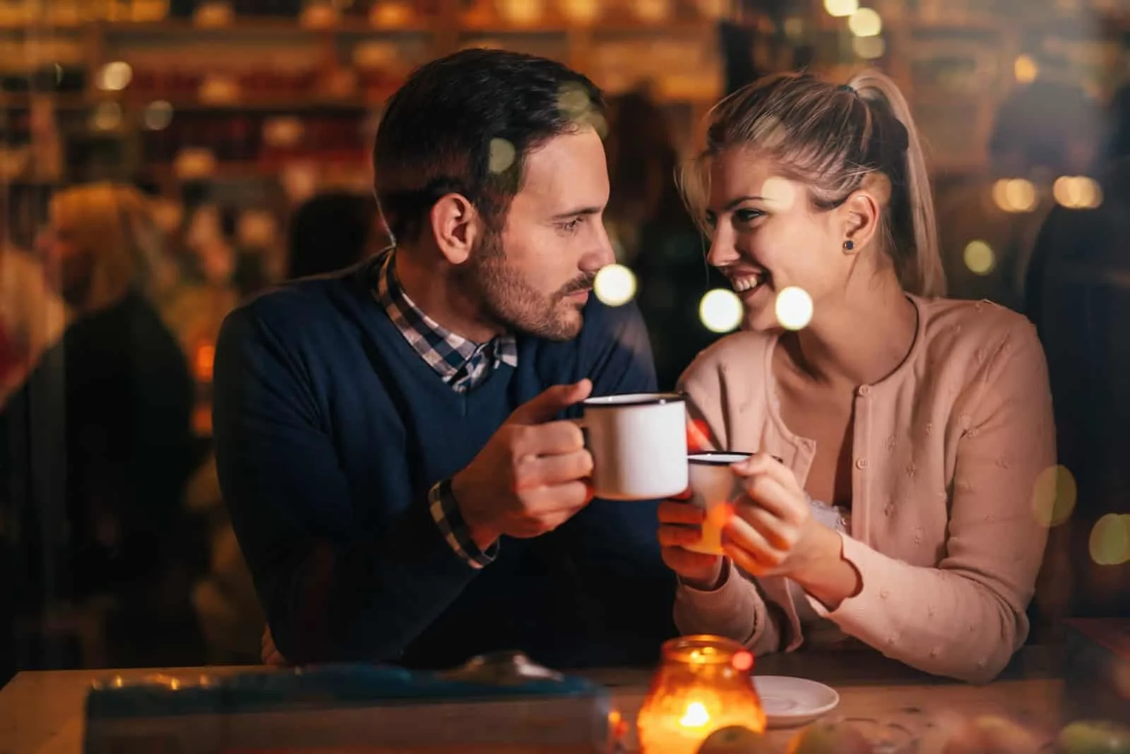 man looking at woman while sitting in cafe