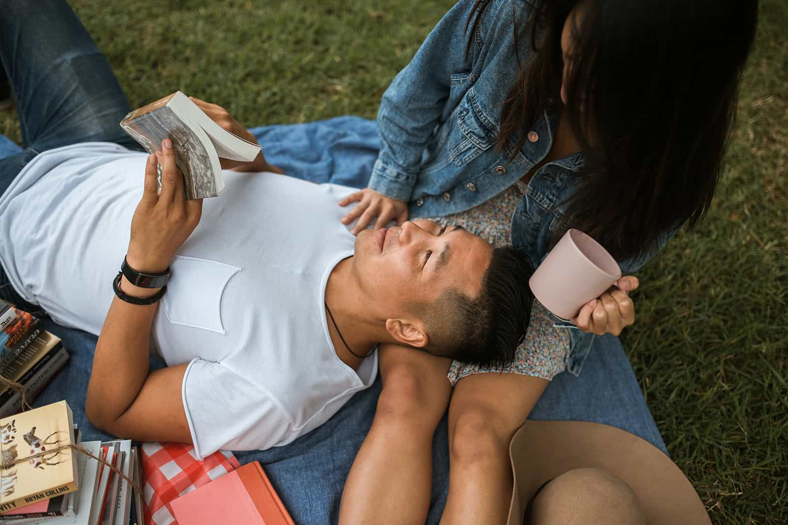 man reading poetry to his girlfriend on a picnic