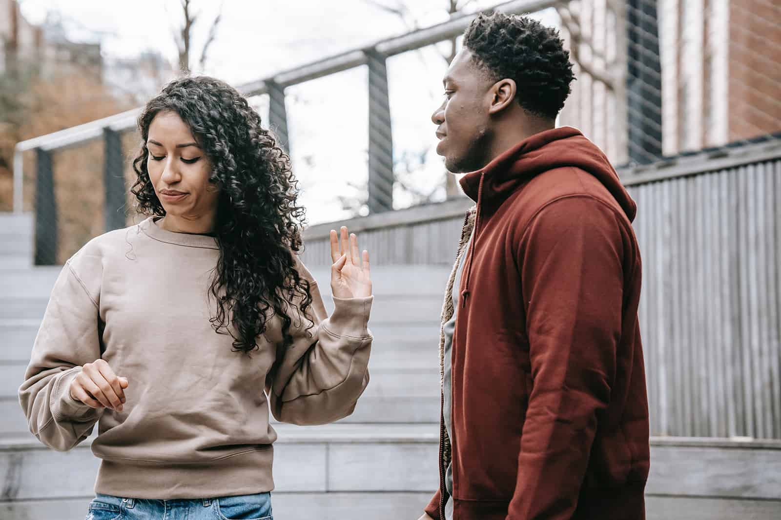 man talking with an upset woman while standing outdoor together