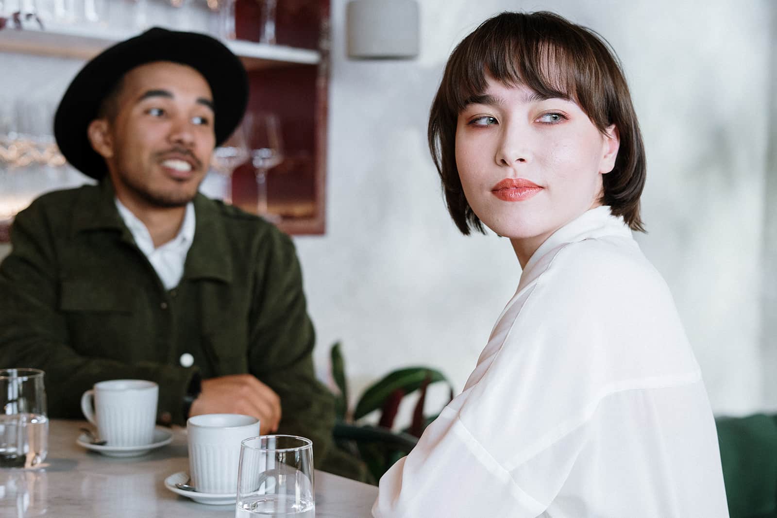 pensive woman sitting with a man in a cafe on a date