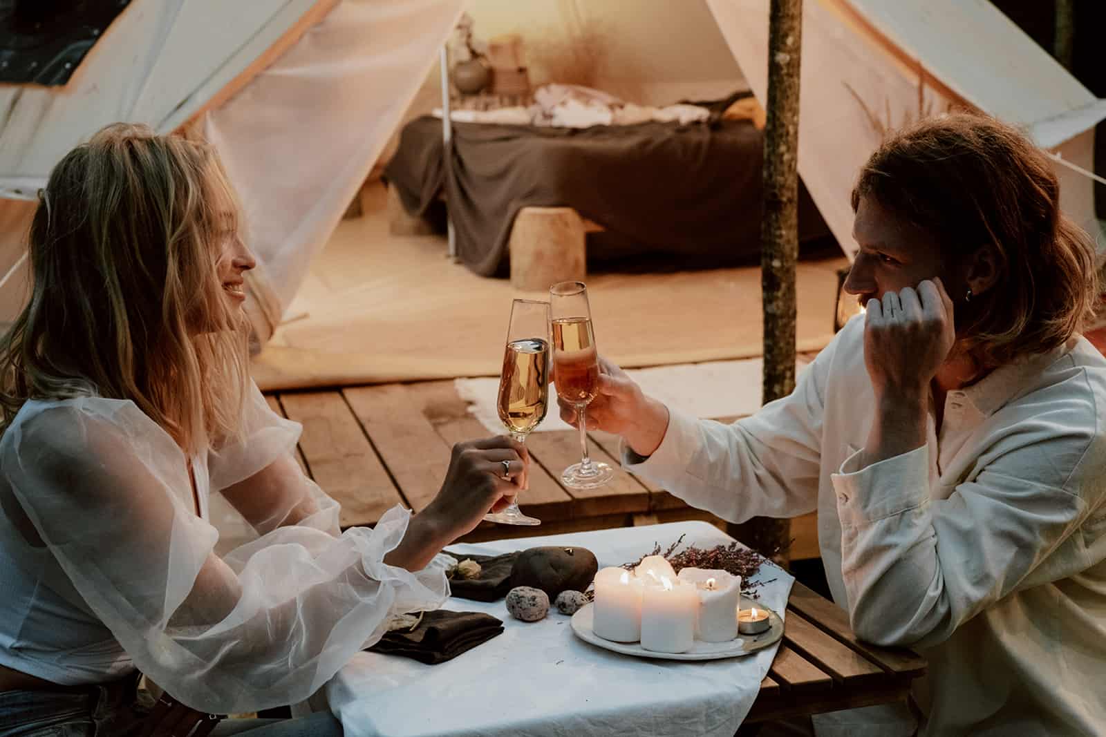 romantic couple toasting with champagne at dinner on the beach