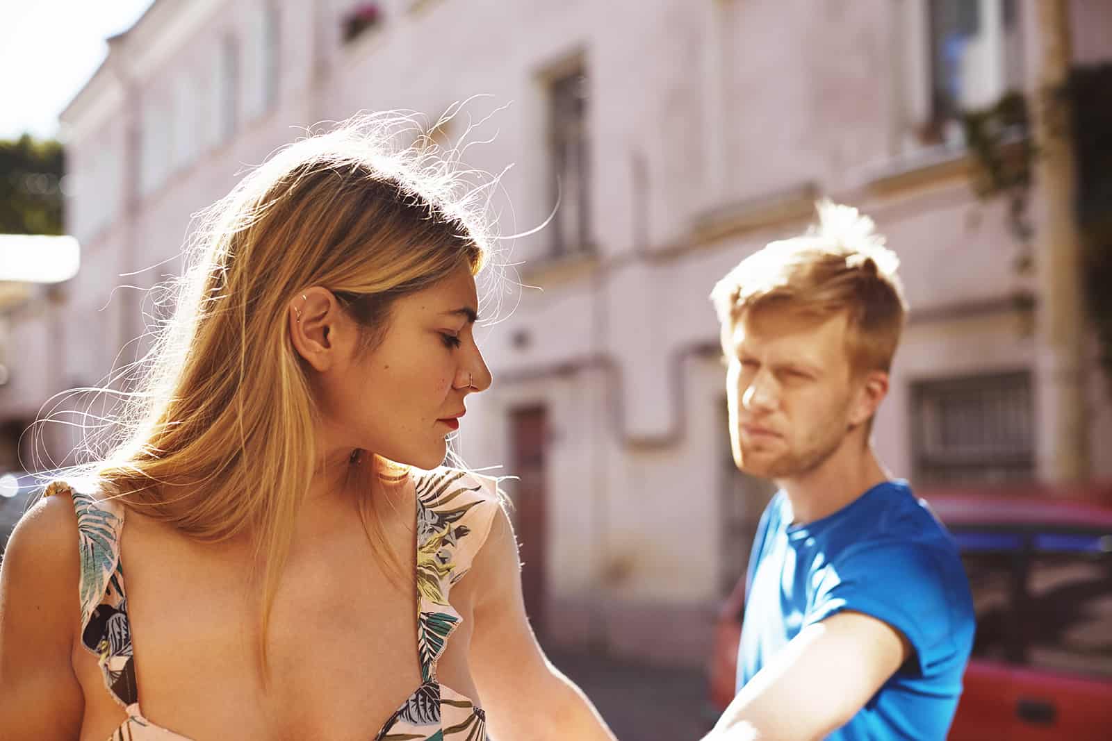 serious woman leaving from a man standing on the street