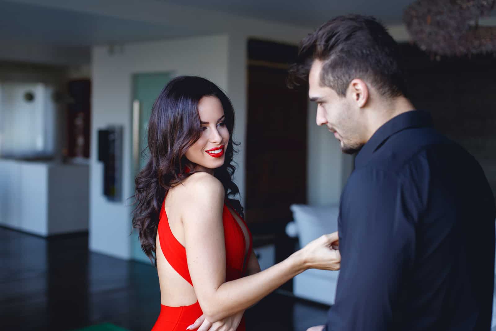 sexy brunette in red dress flirts with man