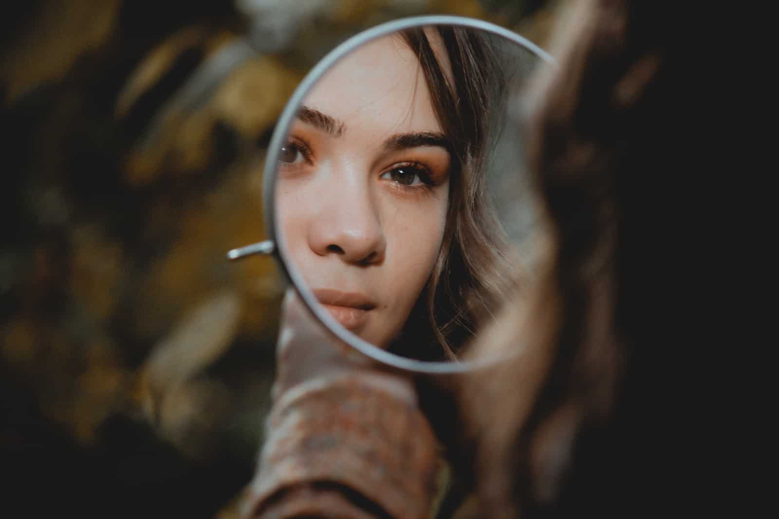 mujer mirándose al espejo y pensando