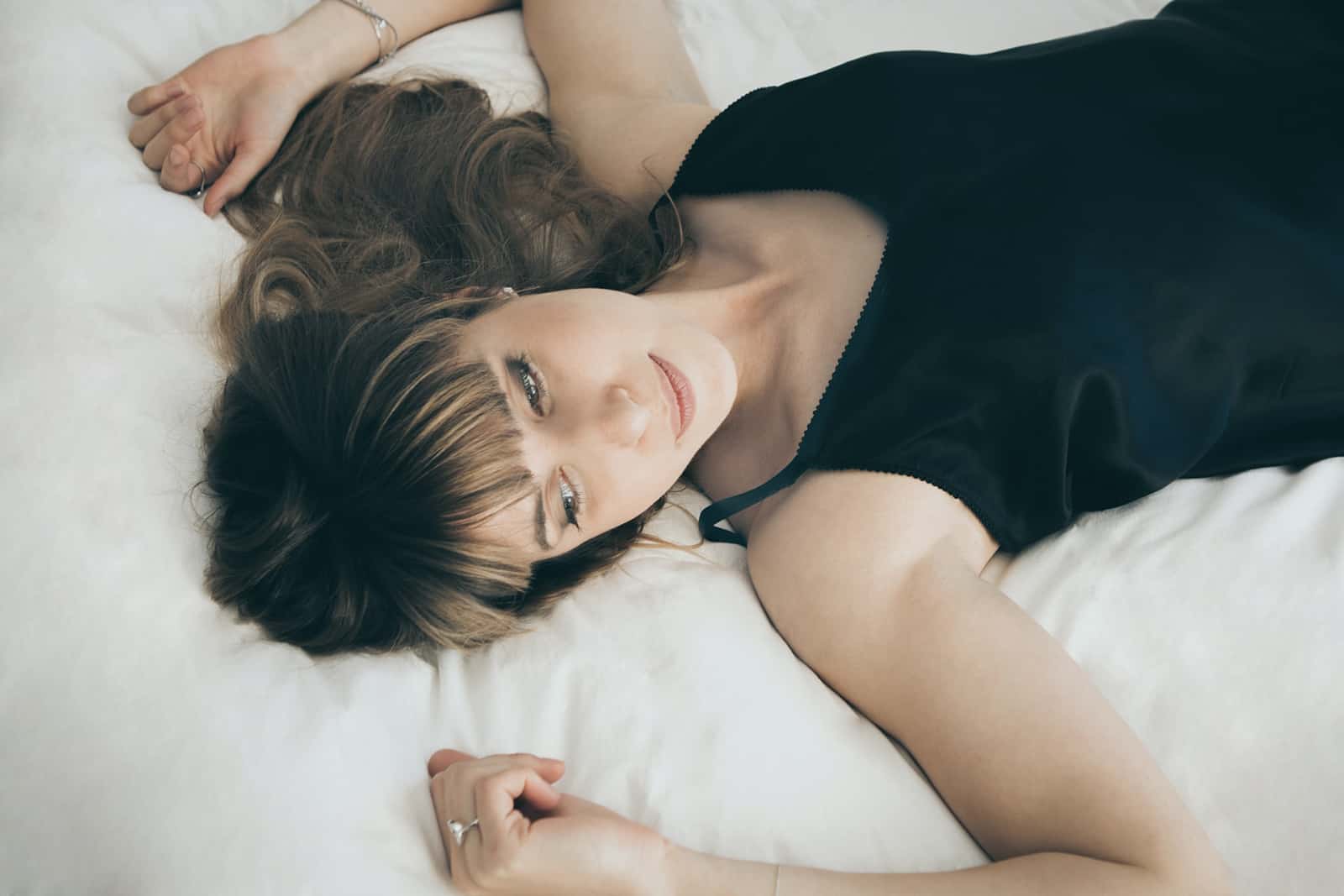 mujer tumbada en la cama con aspecto ausente