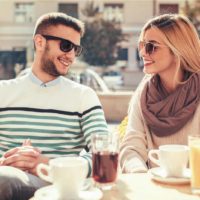 a smiling man and woman sit and talk