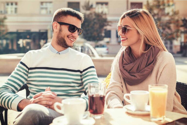 a smiling man and woman sit and talk