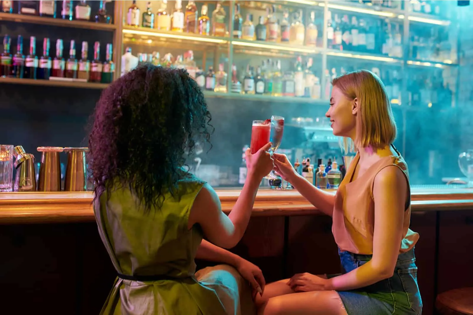 Two women having fun drinking cocktails