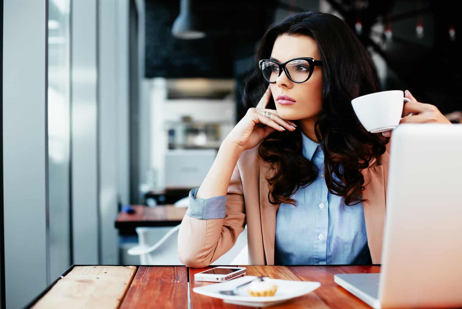 una mujer imaginaria sentada en una mesa tomando café