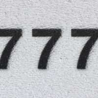numero nero 777 sul muro bianco