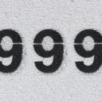 Il numero 999 nero sul muro bianco