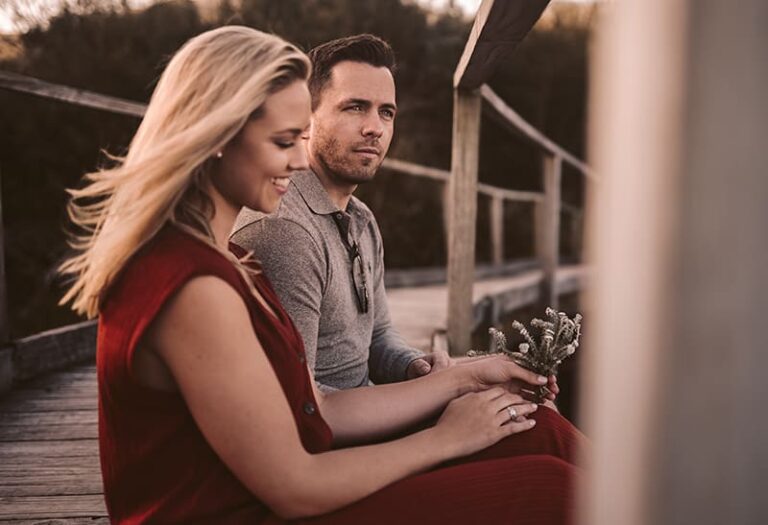 man and woman sitting on the bridge