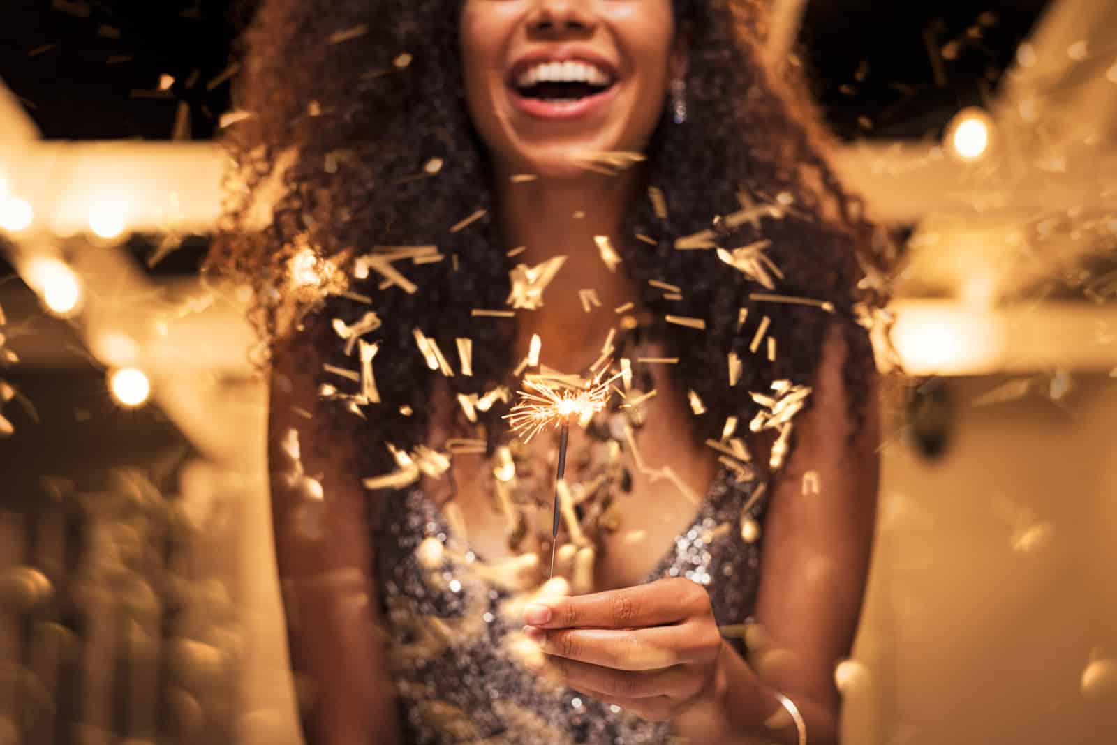 Cheerful young woman holding a sparkler