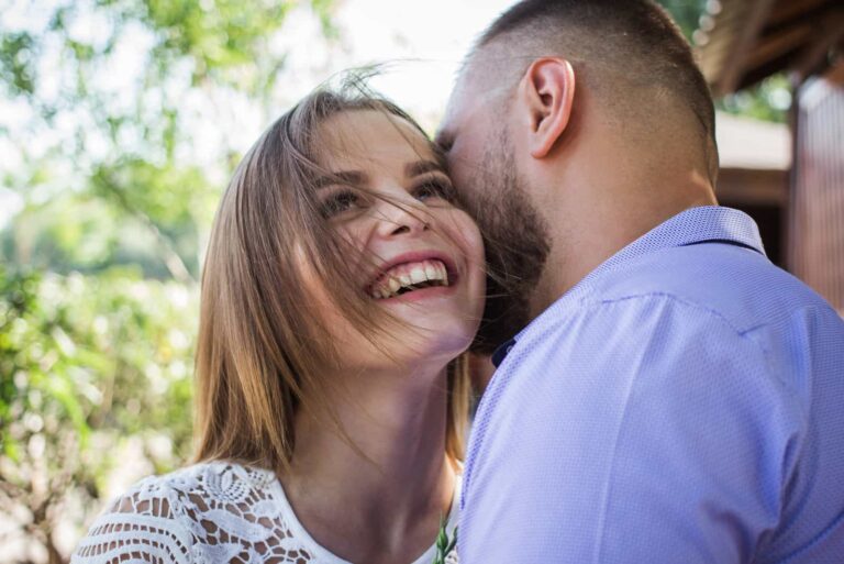 a smiling woman in a man's arms