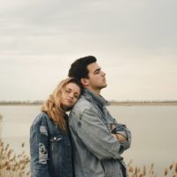 woman leaning on back of her serious boyfriend