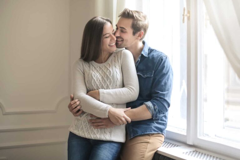 a man and a woman stand embracing
