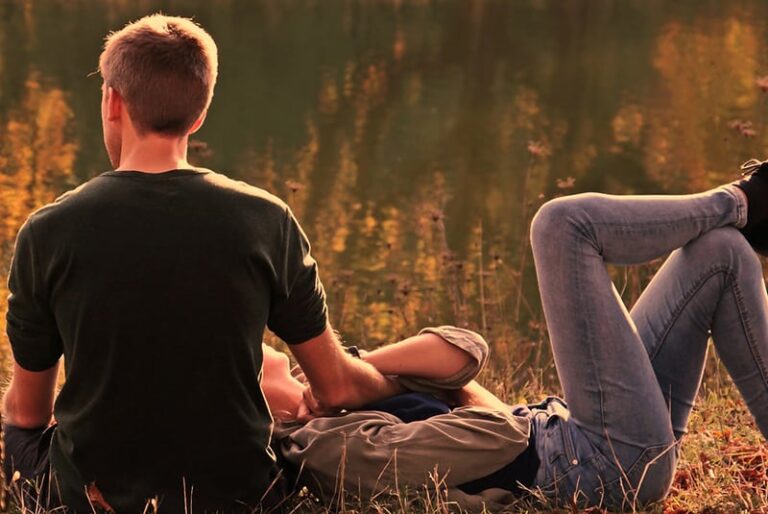 a woman lying in man's arms in the park
