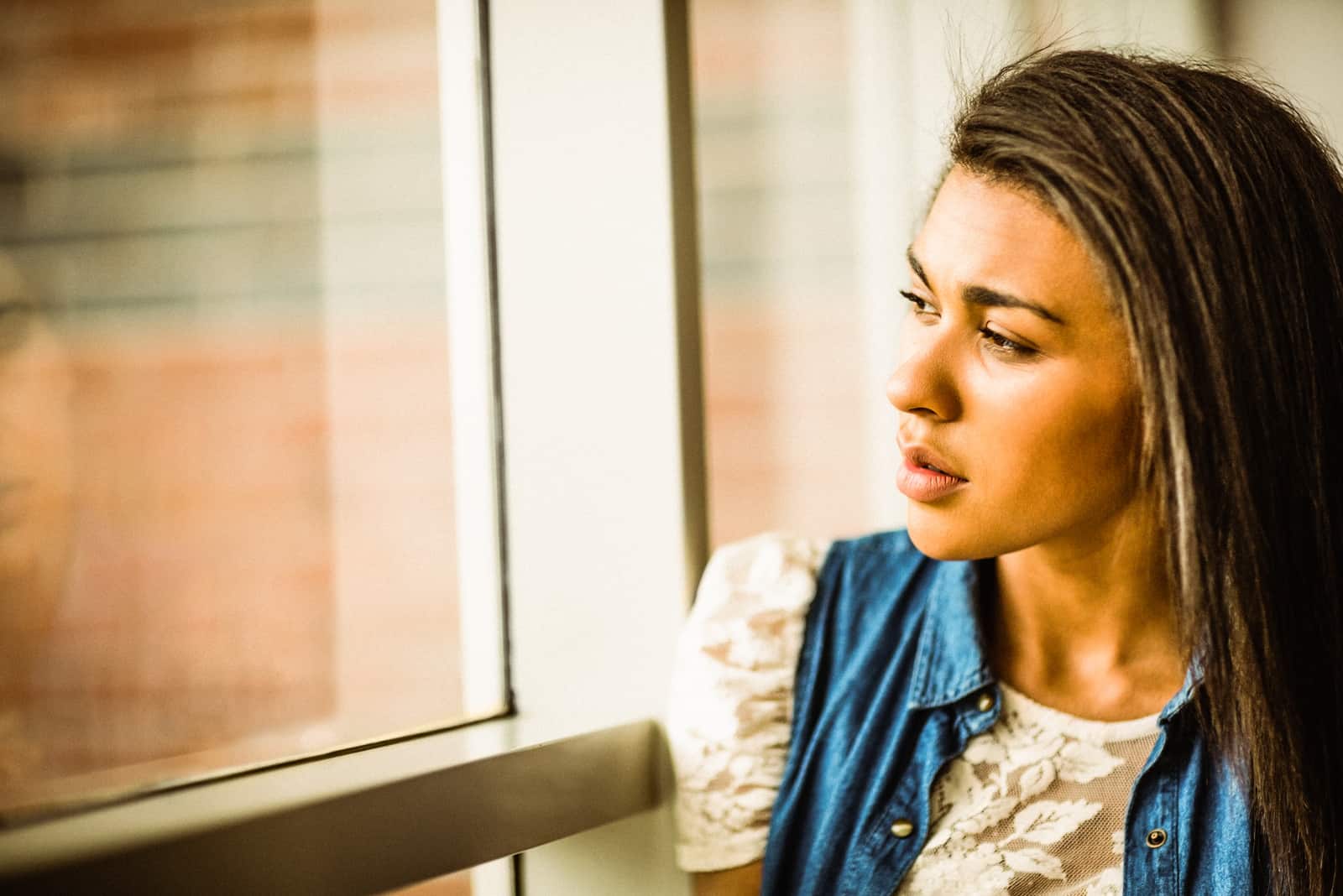 a brown-haired woman sitting by the window