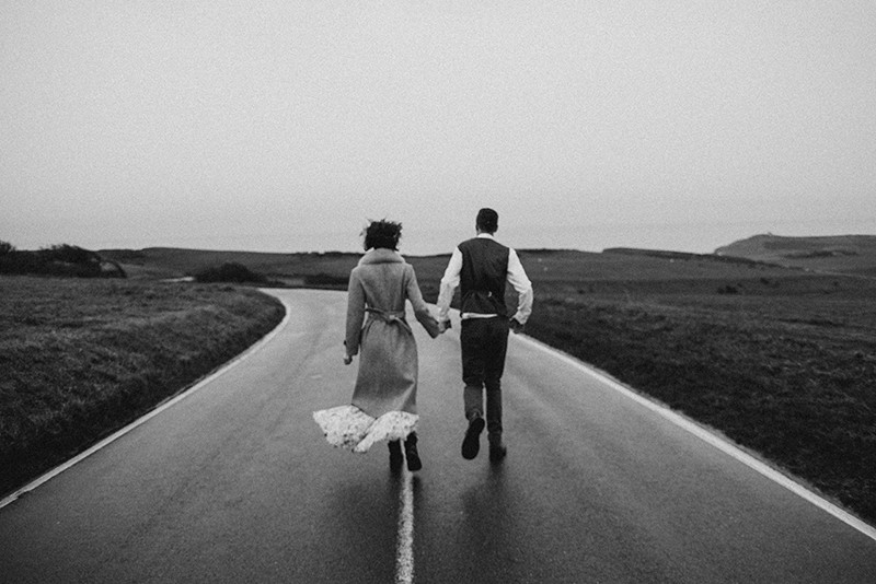 a couple walking on the road and holding hands
