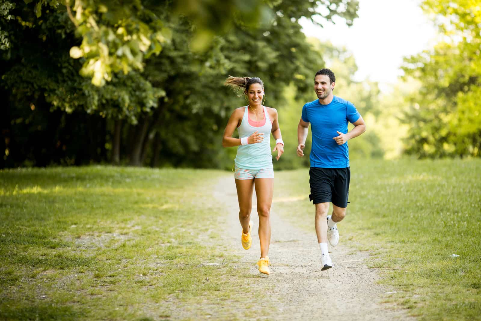 um homem e uma mulher atravessam o campo a correr