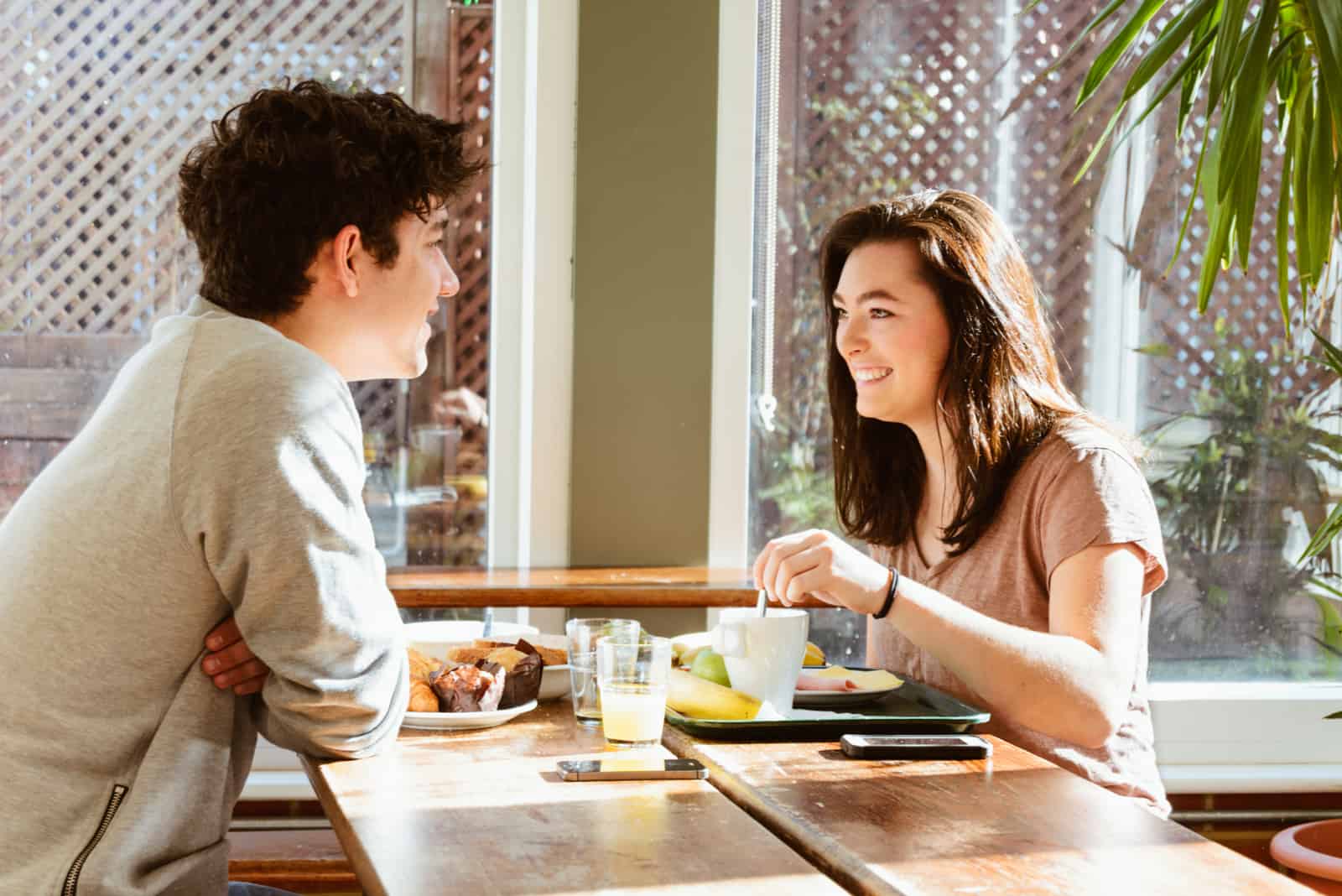 a man and a woman sit at a table and talk