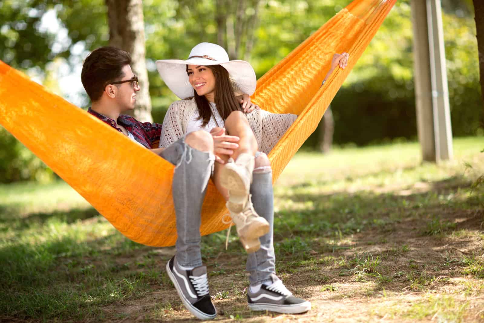 a man and a woman sit on a swing