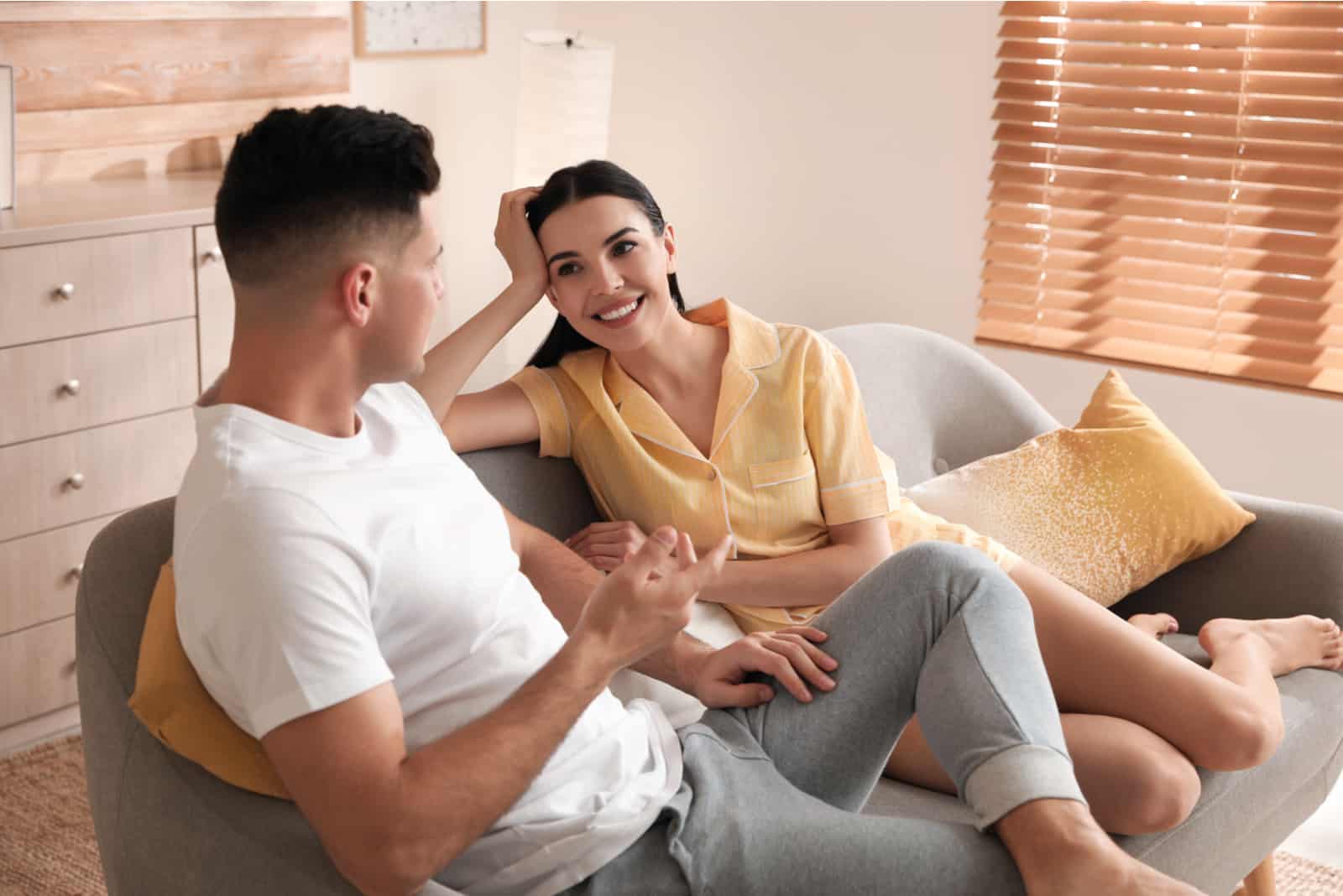 a man and a woman sit on the couch and talk