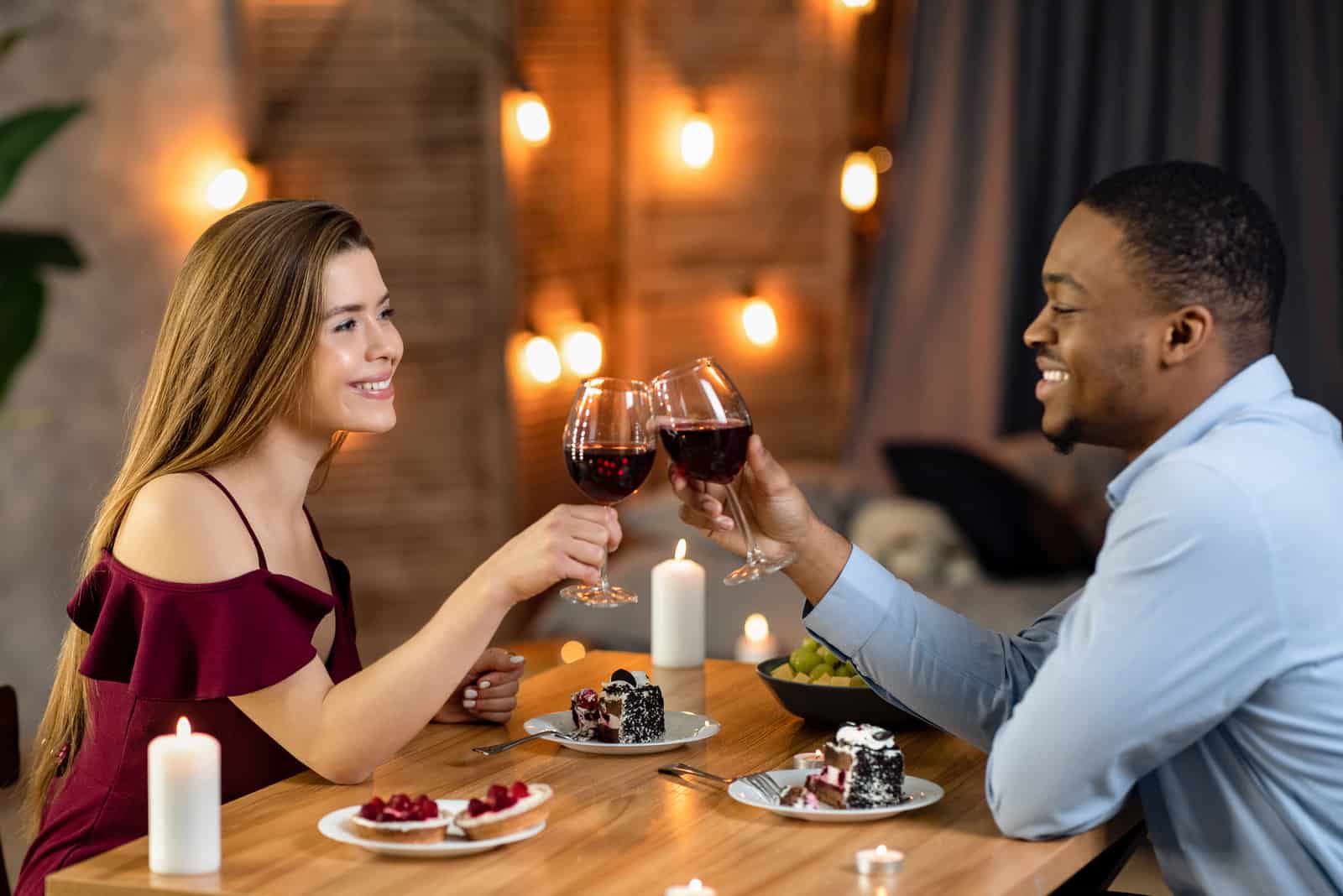 un uomo e una donna seduti a un tavolo per brindare con il vino