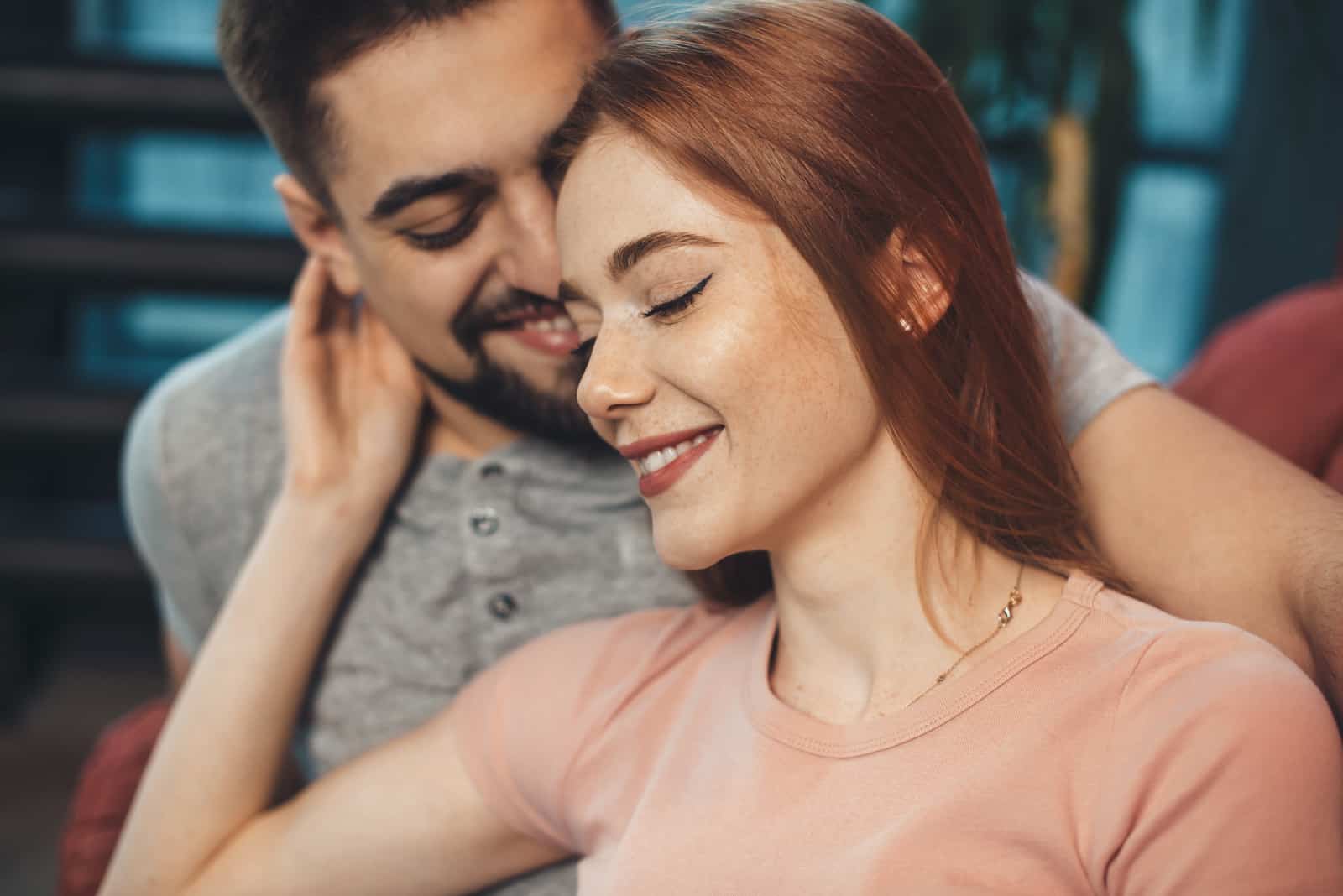 a man and a woman stand embracing