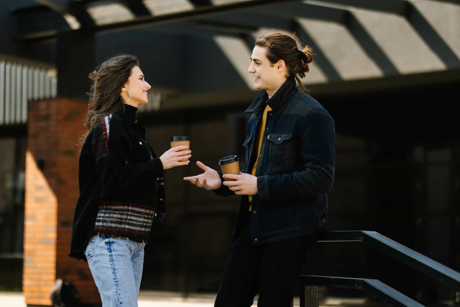 a man and a woman stand on the street and talk