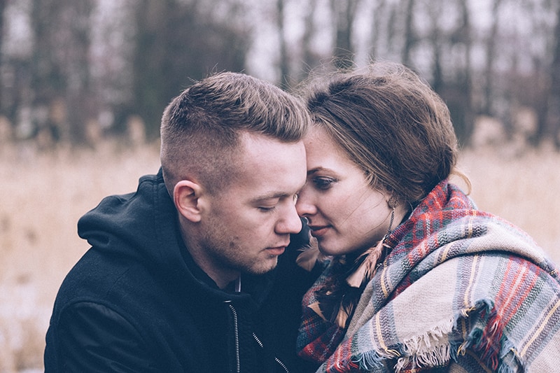 a man and woman cuddling in field