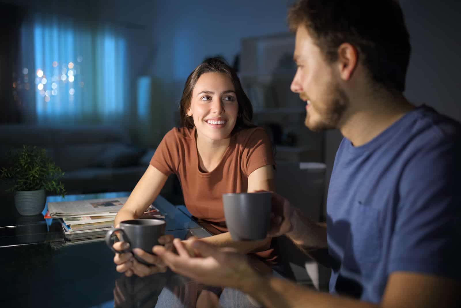 un uomo e una donna sorridenti che parlano davanti a un caffè