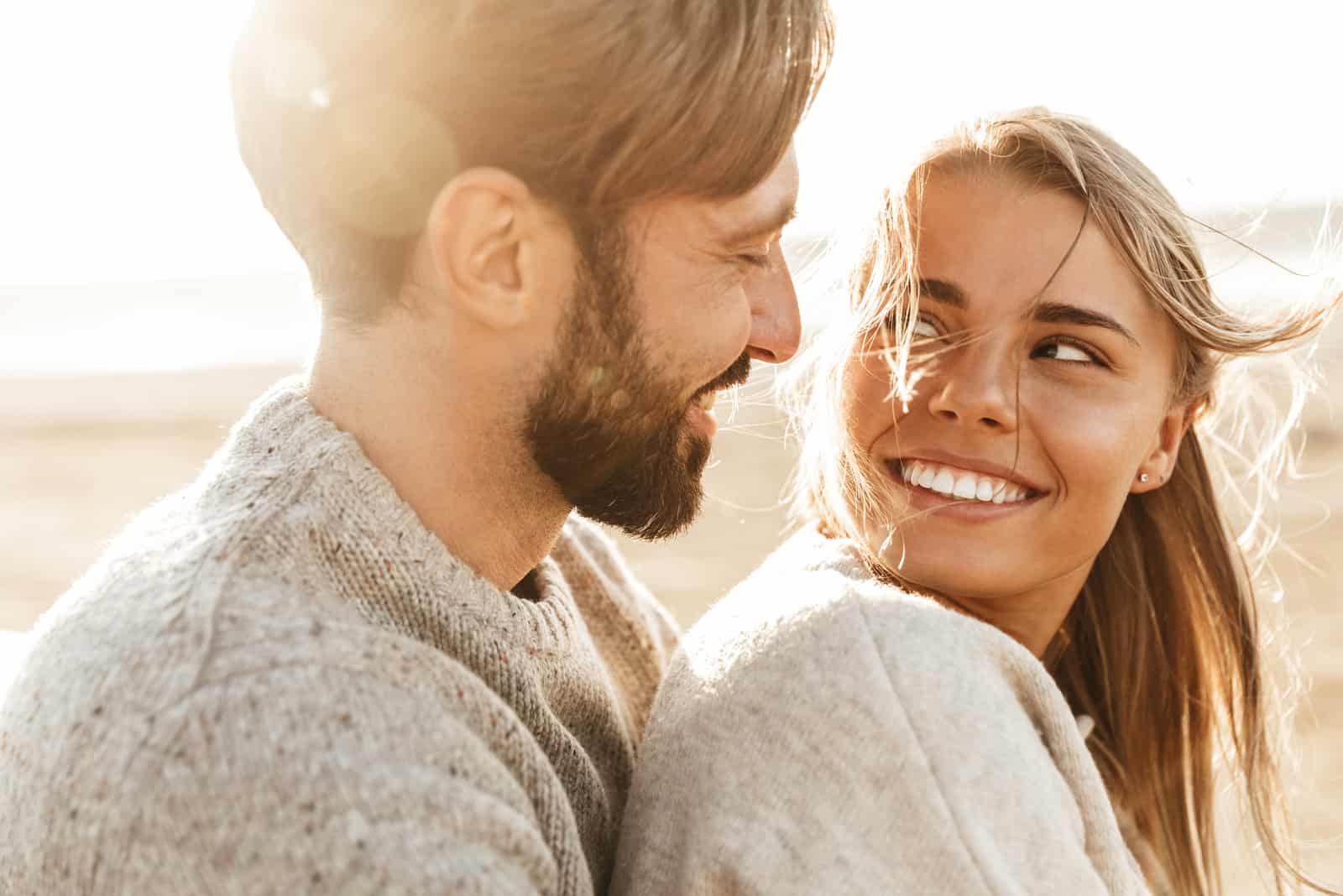 un hombre sonriente abrazó a la mujer de pelo rubio