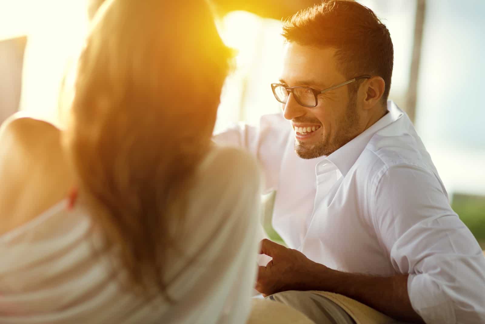 un hombre sonriente hablando con una mujer