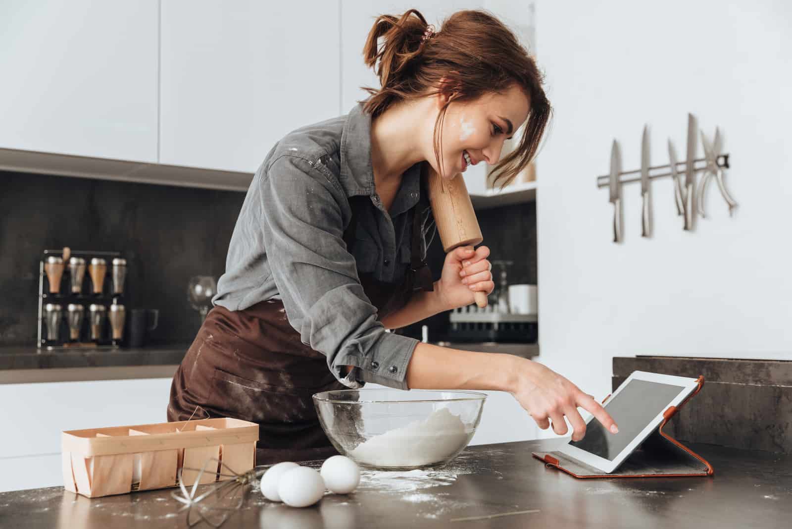 uma mulher sorridente na cozinha faz bolos