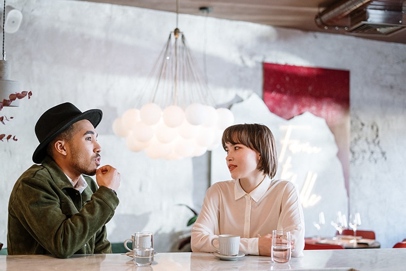 a woman listening to a friend while sitting together in a cafe