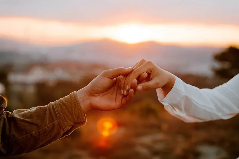couple holding hands during sunset